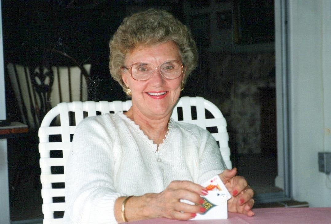 Jean smiling while holding playing cards
